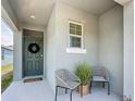 Inviting covered front porch with comfortable seating, perfect for relaxing at 1304 Berry Ln, Davenport, FL 33837