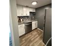 Compact kitchen featuring white cabinets, stainless steel appliances, and granite countertops at 131 Water Front Way # 220, Altamonte Springs, FL 32701