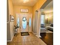 Inviting foyer with tile flooring, decorative columns, and views of the living room, setting a stylish tone at 14963 Braywood Trl, Orlando, FL 32824