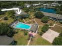 Aerial view of community featuring pool, playground, a pond and well-maintained green spaces at 1695 Lee Rd # E215, Winter Park, FL 32789