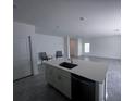 The kitchen island features a sink, cabinets, and a dishwasher, and it opens to the dining room and living room at 1796 Foreman Rd, Eagle Lake, FL 33839