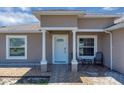 Inviting front porch with two chairs and a small table between white columns and fresh landscaping at 199 Maple Dr, Kissimmee, FL 34759