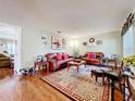 Bright living room with hardwood floors, leather sofas, area rug, and tasteful décor creating a warm ambiance at 1930 Knollcrest Dr, Clermont, FL 34711