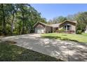 Charming single Gathering home featuring a long driveway, two-car garage, and manicured lawn at 2074 King Richards Ct, Orange City, FL 32763