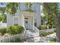 Charming two-story home featuring a welcoming front porch, blue door, and a well-maintained picket fence at 212 Ficus St, Celebration, FL 34747