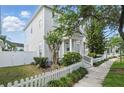 Charming two-story home featuring a welcoming front porch and a well-maintained picket fence and sidewalk at 212 Ficus St, Celebration, FL 34747