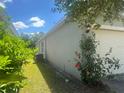 Side view of the home featuring lush foliage and an outside light fixture at 219 Duke Dr, Deland, FL 32724