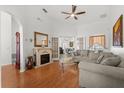 Bright living room featuring a fireplace, ceiling fan, hardwood floors, and comfortable sofas at 2289 Jessica Ln, Kissimmee, FL 34744