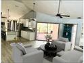 Bright living room features vaulted ceiling, pendant lighting, and a large glass slider to the pool at 2615 Autumn Green Dr, Orlando, FL 32822