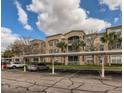 Condo complex with covered parking, landscaped grounds, and light stucco exterior at 3025 Greystone Loop # 302, Kissimmee, FL 34741