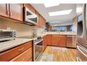 Kitchen featuring wood cabinets, granite counters, tile backsplash, and stainless steel appliances and oven at 4 Oceans West Blvd # 301B, Daytona Beach Shores, FL 32118