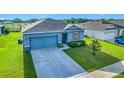 Charming blue single-Gathering home with a well-maintained lawn, long driveway, and manicured landscaping at 452 Burnham Cir, Auburndale, FL 33823