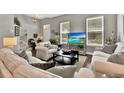 Bright living room with white sofas, decorative pillows, and a view of a tropical scene on the TV at 541 Campus St, Celebration, FL 34747