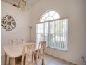 Elegant dining room with arched window, chandelier, and seating for four for comfortable Gathering meals at 624 Montana Ave, Davenport, FL 33897