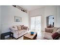 Bright living room with sliding glass doors, neutral tones, and a view into the dining area at 624 Montana Ave, Davenport, FL 33897