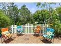 Charming backyard featuring colorful Adirondack chairs and a white picket fence at 6886 Sundrop St, Harmony, FL 34773