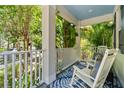 Relaxing front porch with rocking chairs and lush tropical landscaping at 6886 Sundrop St, Harmony, FL 34773