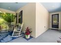 Inviting front porch with rocking chairs, blue rug, and colorful plants at 6886 Sundrop St, Harmony, FL 34773