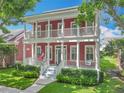 Inviting two-story home features a charming red exterior, double balconies, and a welcoming front porch at 715 Honeysuckle Ave, Celebration, FL 34747