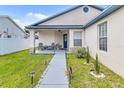 Cozy front porch with seating, decorative plants, and manicured landscaping at 7830 Myrtle Oak Ln, Kissimmee, FL 34747