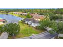 An aerial view showcases the home's serene lake view and beautiful landscaping in a friendly neighborhood at 817 Grand Canal Dr, Kissimmee, FL 34759