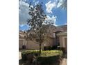 Charming home exterior featuring lush trees and landscaping with a two car garage and tile roof at 8369 Riverdale Ln # 1, Davenport, FL 33896