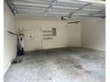 Spacious two car garage with water heater, storage shelves, and door to interior of home at 8369 Riverdale Ln # 1, Davenport, FL 33896