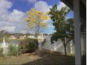 Scenic backyard view with flowering trees and a classic white picket fence at 954 Hacienda Cir, Kissimmee, FL 34741