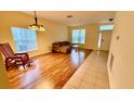 Bright living room with wood flooring, large windows, and a comfortable seating area at 954 Hacienda Cir, Kissimmee, FL 34741