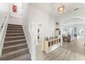 Bright and modern foyer with wood-look tile, staircase, and an arched entryway to the living area at 14314 Pleach St, Winter Garden, FL 34787