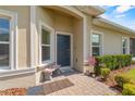 Inviting entryway with a brick walkway, small bench, and charming landscaping at 1000 Blackwolf Run Rd, Davenport, FL 33896