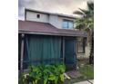 Exterior view showing a screened-in porch, lush vegetation, and architecture details of the home at 135 Pine Island Cir, Kissimmee, FL 34743