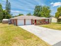 Lovely single-story home boasting a brick exterior, green lawn, and convenient two-car garage at 1594 Frances St, Kissimmee, FL 34744