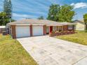 Attractive single-story house showcasing brick details, a spacious driveway, and an attached garage at 1594 Frances St, Kissimmee, FL 34744