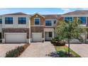Charming townhome featuring a stone-accented facade, brick driveway, and a manicured front yard at 1809 Portofino Meadows Blvd, Orlando, FL 32824