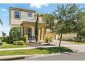 Beautiful two-story home with a well-maintained lawn, mature trees, and a welcoming front porch with seating area at 1817 Caribbean View Ter, Kissimmee, FL 34747
