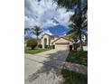 Two-story home featuring a two-car garage, arched entryway, and lush green front lawn at 1960 Aspenridge Ct, Ocoee, FL 34761