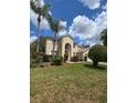 Two-story home featuring an arched entryway, lush green front lawn, and manicured landscaping at 1960 Aspenridge Ct, Ocoee, FL 34761