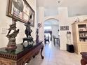 Elegant hallway with tile flooring, arched doorway, and decorative statues on a console table at 2511 Balmoral Dr, Kissimmee, FL 34744
