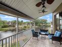 The screened-in patio includes ceiling fans and comfortable furniture overlooking a serene lake at 2662 Emerald Lake Ct, Kissimmee, FL 34744