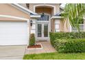 Inviting front entrance showcasing double doors with decorative glass and landscaped surroundings at 301 Wingdale Way, Davenport, FL 33897