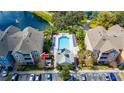 Aerial view of condo building showcasing in-ground community pool with sundeck and lake views at 3344 Corona Village Way # 207, Orlando, FL 32835