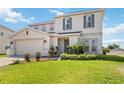 Charming two-story home features a well-manicured lawn and an attached two-car garage at 410 Canna Dr, Davenport, FL 33897