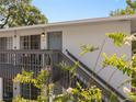 A view of the condo front with a stairway leading to the door and a small balcony with seating at 4820 Conway Rd # 130, Orlando, FL 32812