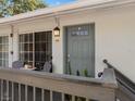 Charming condo entrance featuring a cozy outdoor seating area and stylish gray door at 4820 Conway Rd # 130, Orlando, FL 32812