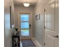 A modern entryway with frosted glass door, console table, decorative mirror, and stylish rug at 637 Ocean Course Ave, Davenport, FL 33896