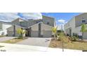 A contemporary townhome with attached two-car garage, stone accents, and manicured landscaping at 637 Ocean Course Ave, Davenport, FL 33896