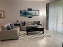 A stylish living room features modern furnishings, area rug, decorative art, and bright natural light at 637 Ocean Course Ave, Davenport, FL 33896