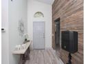 Inviting entryway with wood-look flooring, stylish console table, and decorative wall mirror at 639 Chadbury Way, Kissimmee, FL 34744