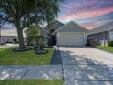 Charming single-story home featuring a well-manicured lawn, mature tree, and two-car garage at 639 Chadbury Way, Kissimmee, FL 34744